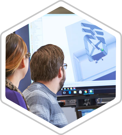 Two people are seated and watching a presentation